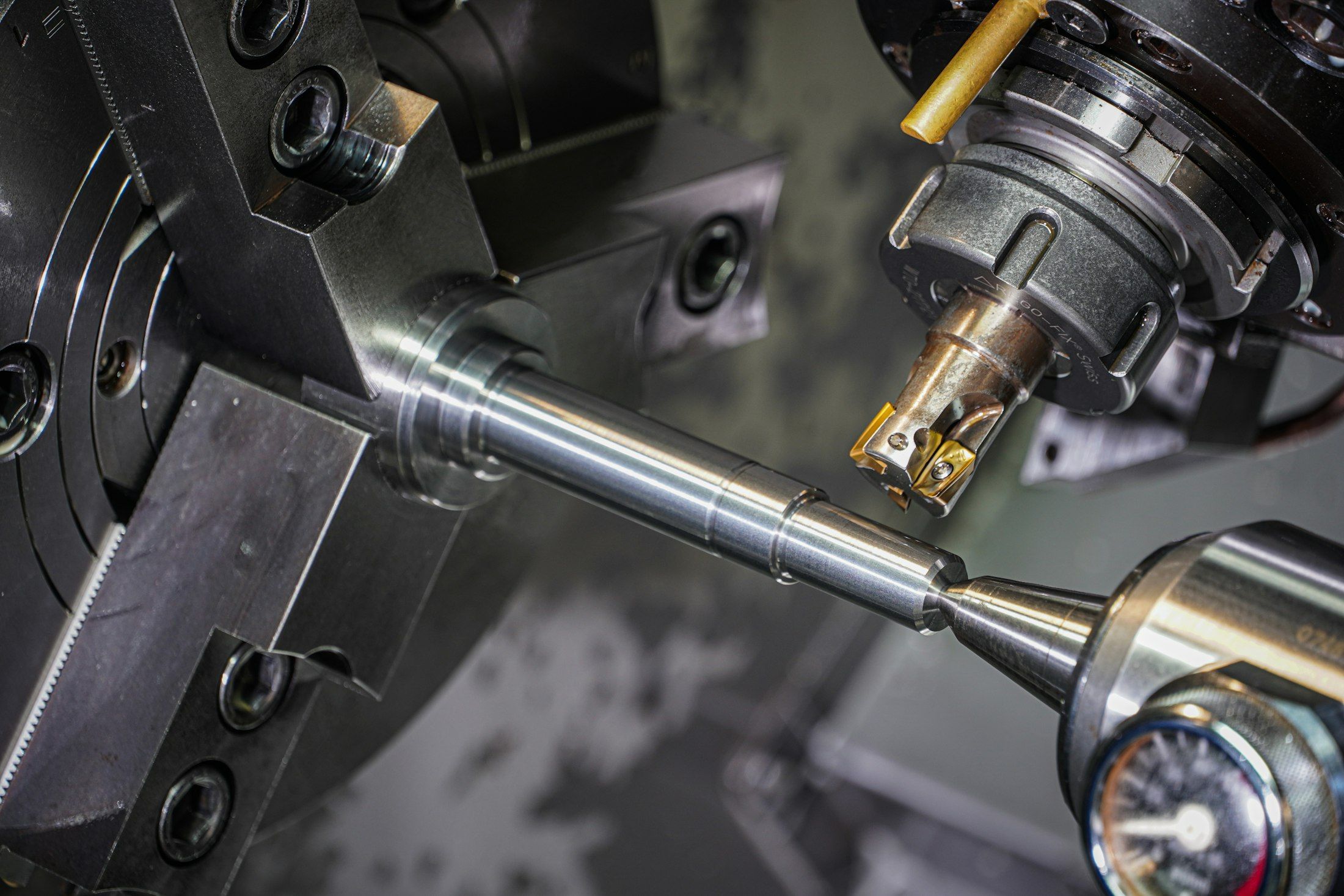 A metal rod being machined on a lathe