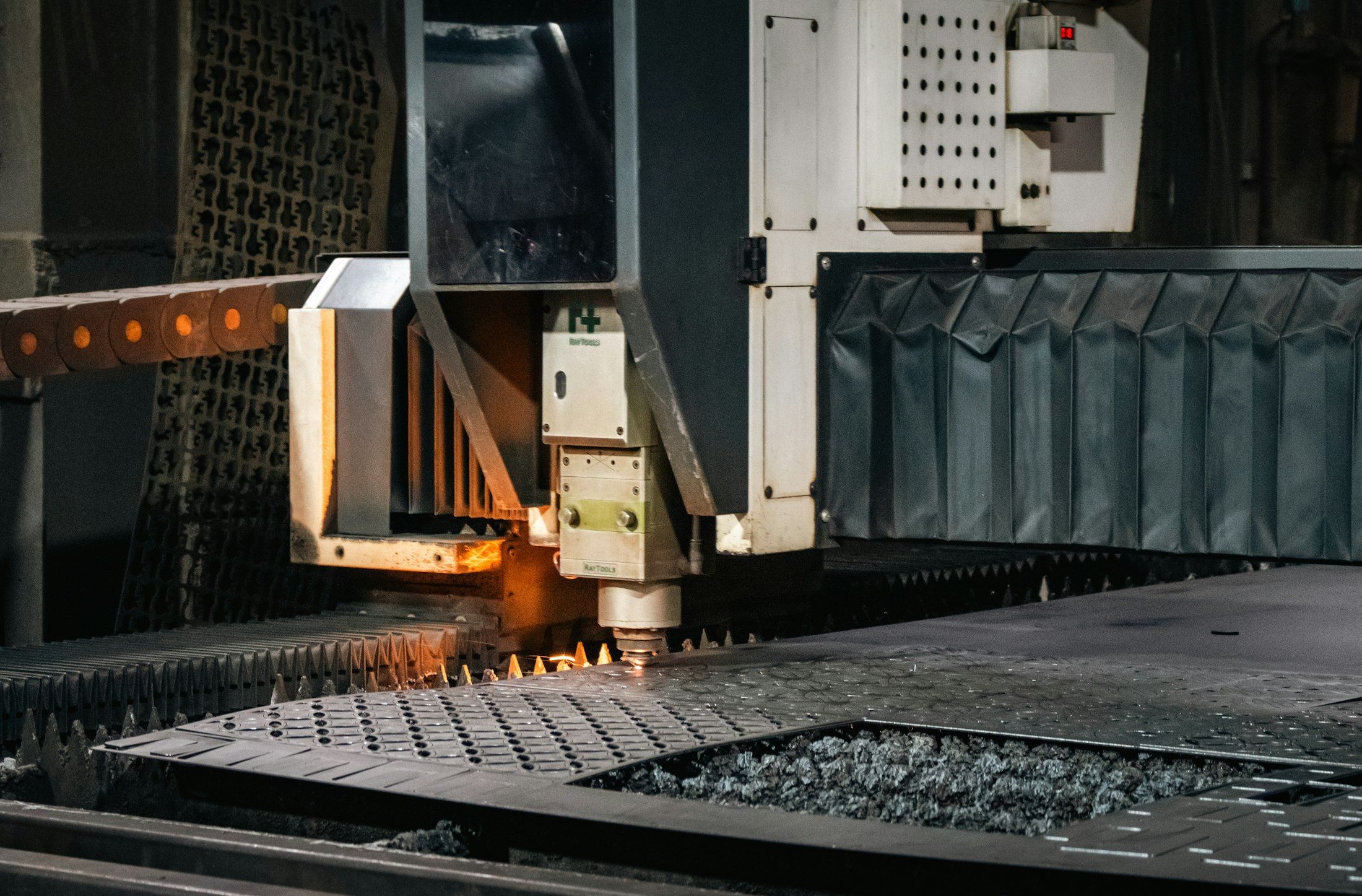 An industrial laser cutter working on a metal sheet