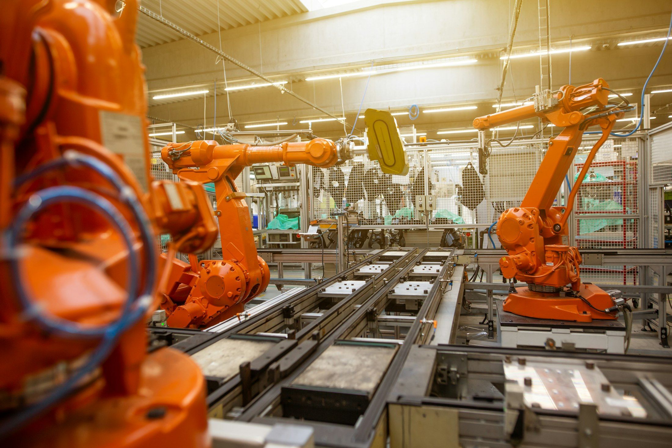 A production hall with rows of orange industrial robots