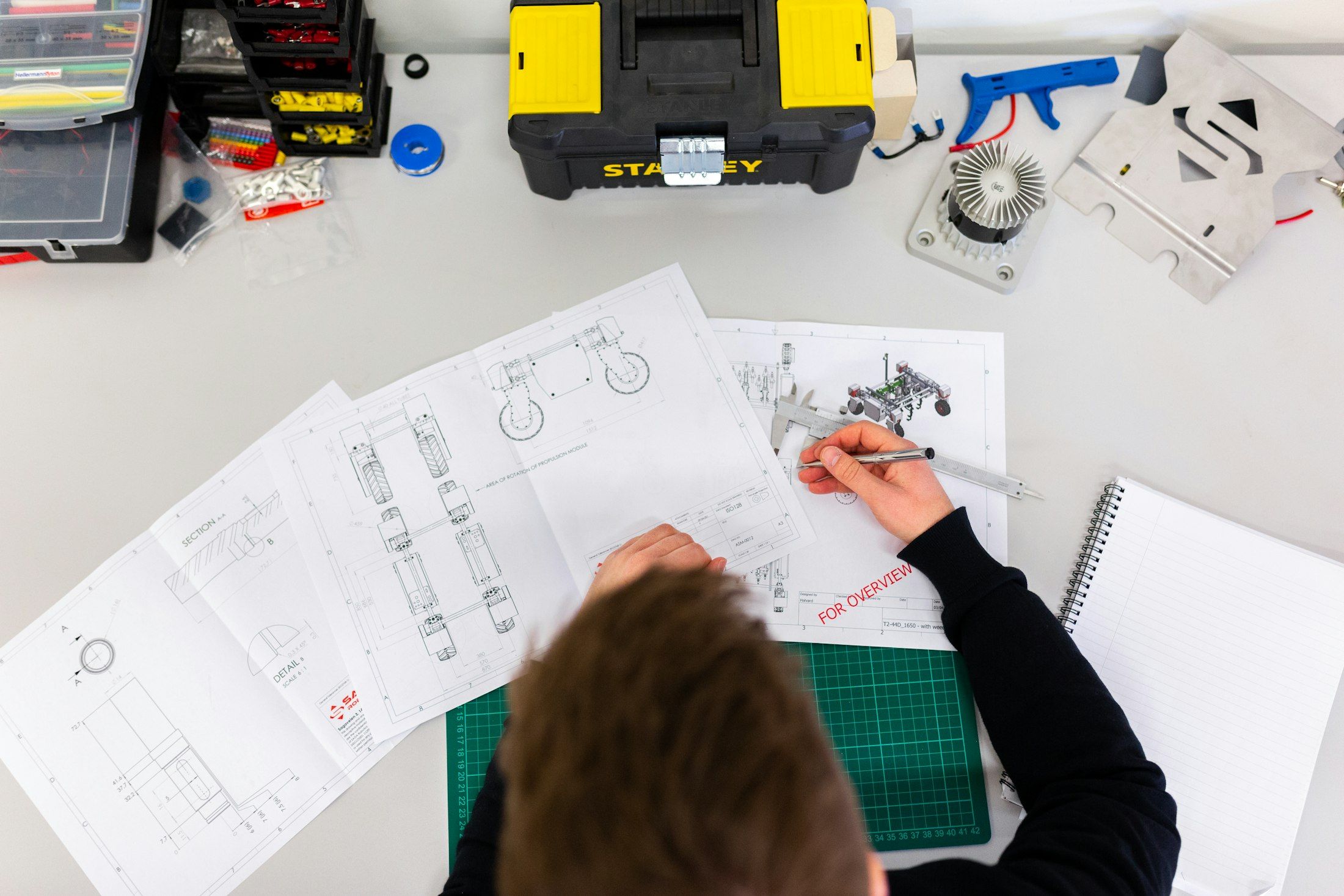 An engineer measuring technical drawings with a caliper
