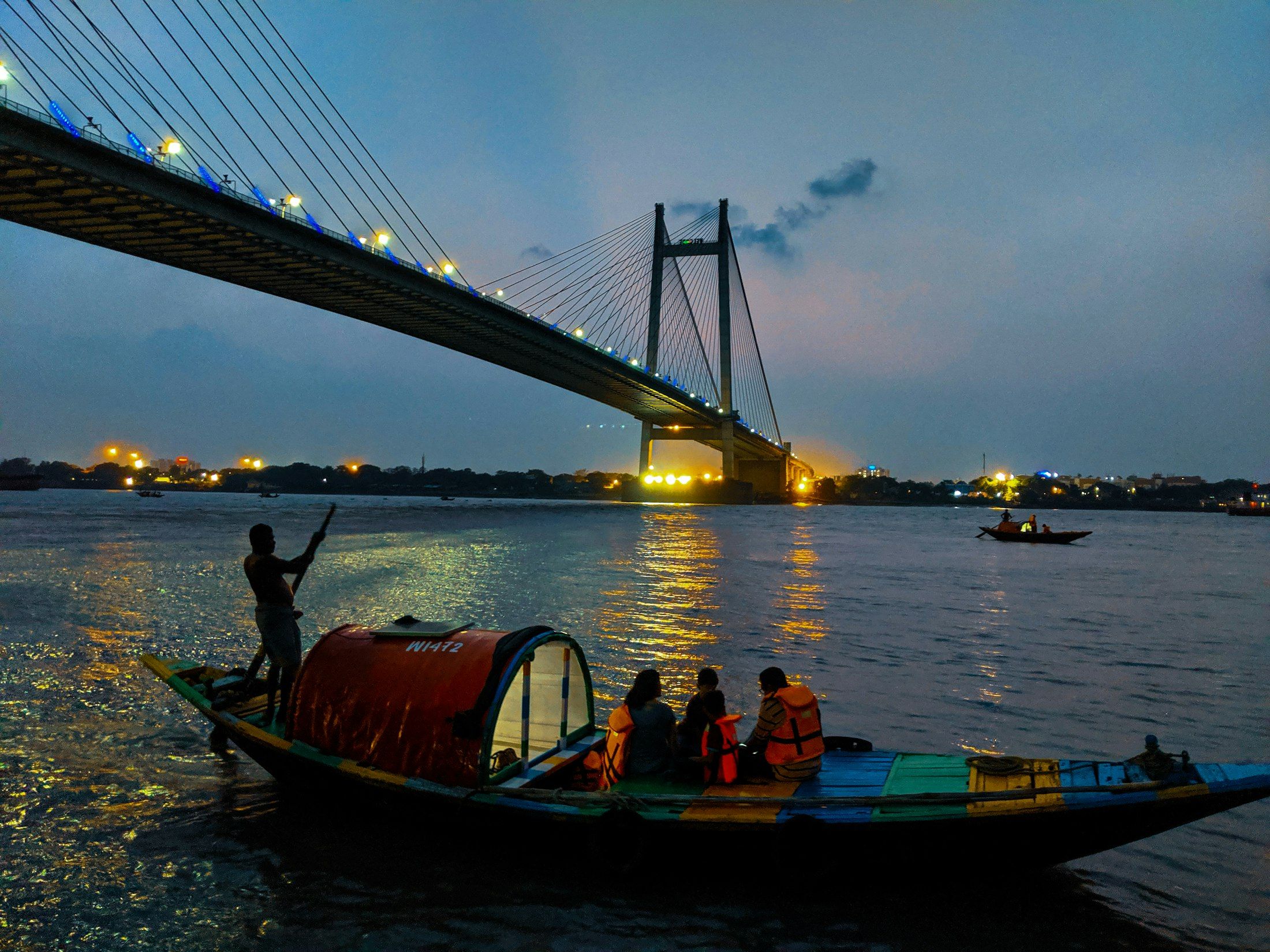 A wooden boat on the Hooghly, the Ganga at Kolkata, beneath the cable-stayed Vidyasagar Setu